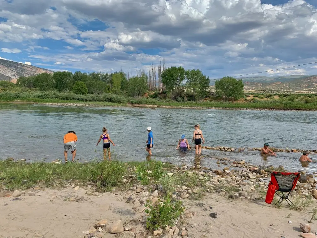 family wades in Green River in Dinosaur National Monument